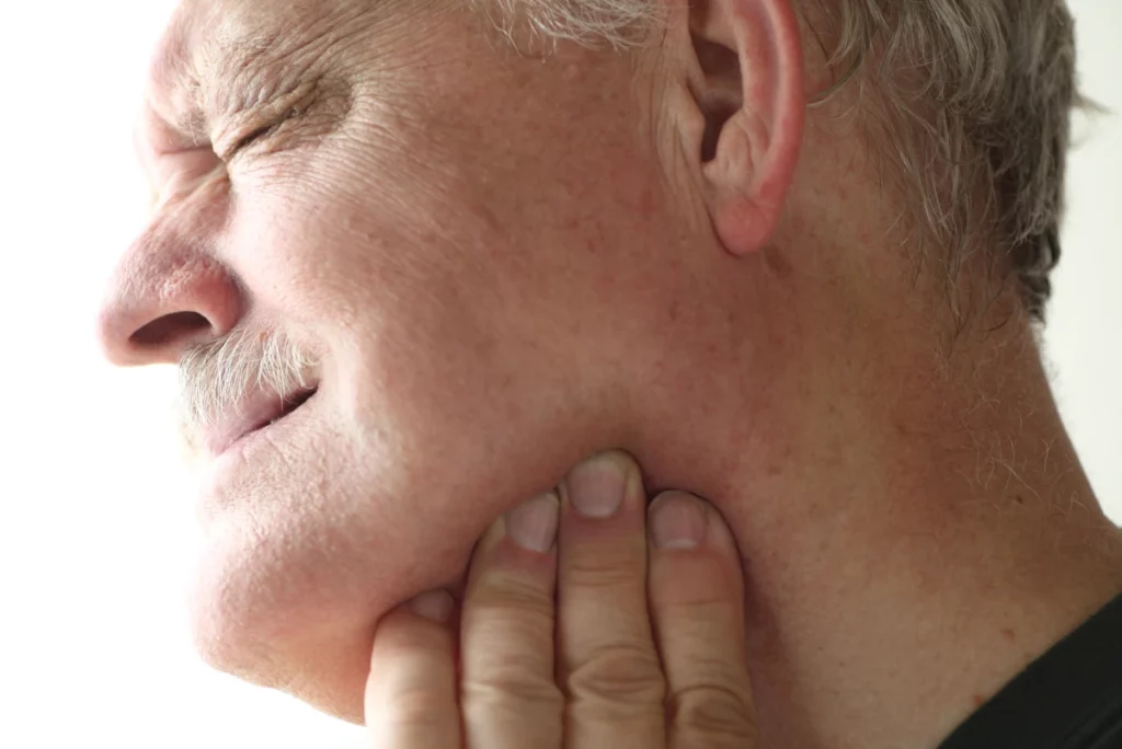 Man holding jaw in pain