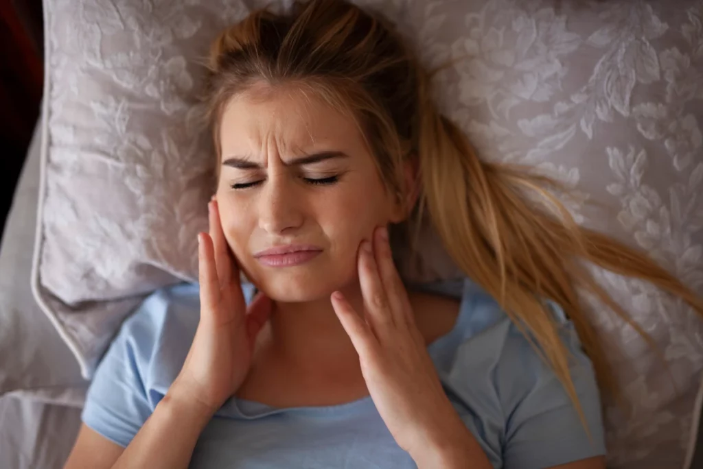 Person with bruxism in pain, grinding their teeth at night