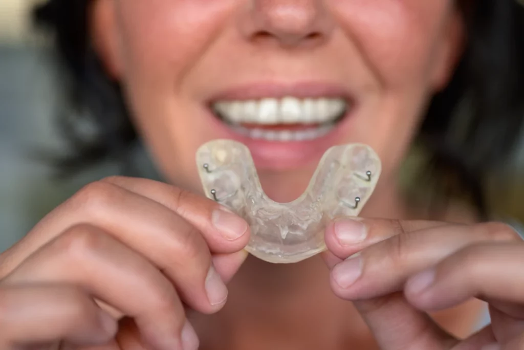 Woman holding clear dental nightguard